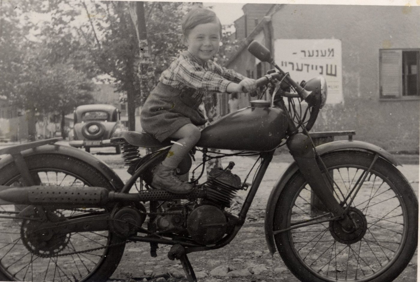 Ruwen Waks auf einem Motorrad vor seinem Haus in Föhrenwald, 1951.